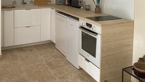 A modern kitchen with white cabinets, a built-in microwave, a dishwasher, and a stove.