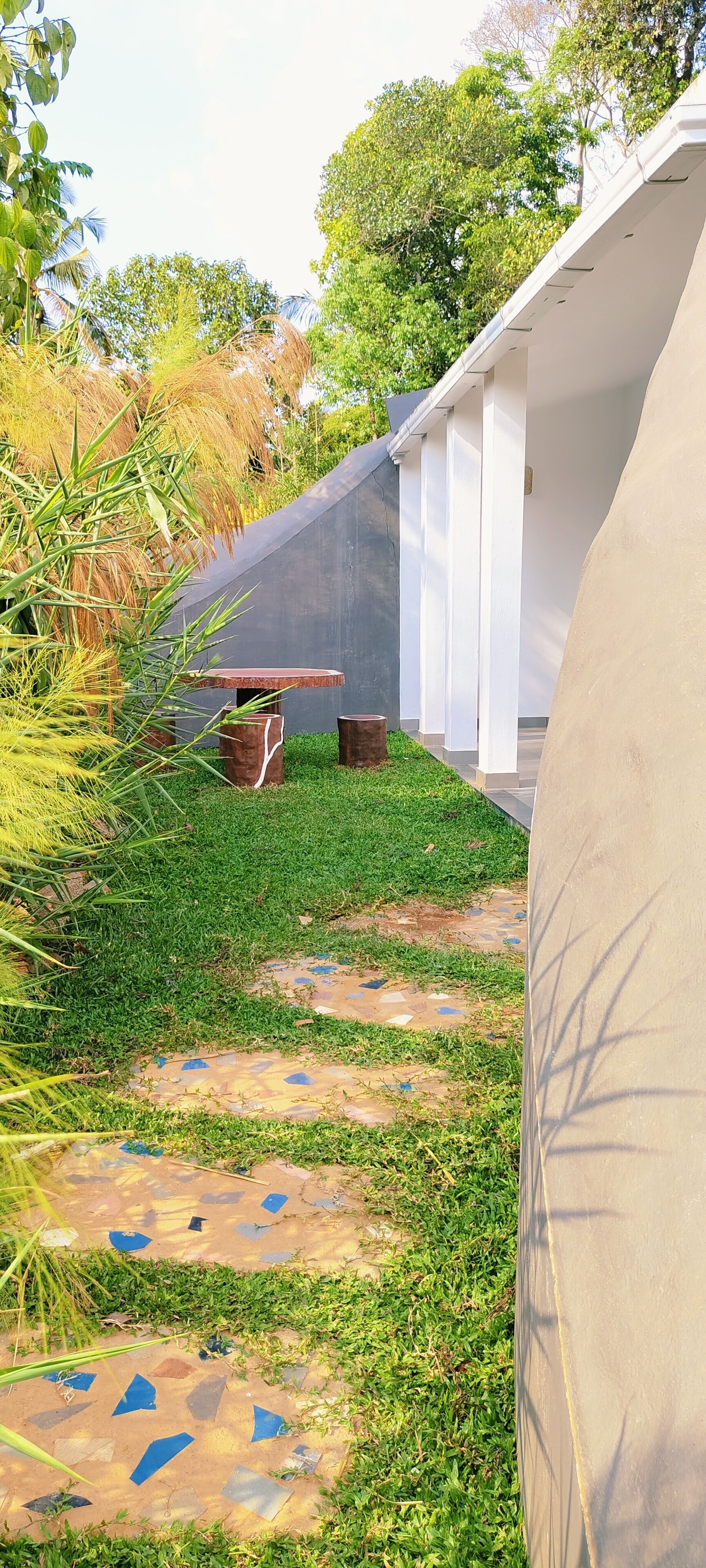 A garden area with a pathway leading to a building with white columns.