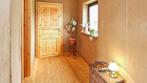 A wooden door, a potted plant, a small table with a lamp, and a window with a view. - 2 bedroom lovely apartment in Mirow (Mirow)