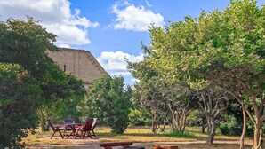 A courtyard with outdoor seating, a large stone structure, and trees. - Ferienwohnung Hohen Wangelin (Hohen Wangelin)