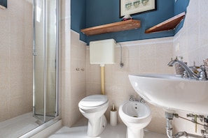 A bathroom with a toilet, bidet, sink, and a glass shower enclosure. - 3799 Case Aida - Casa Celeste 2P by Barbarhouse (Gallipoli)