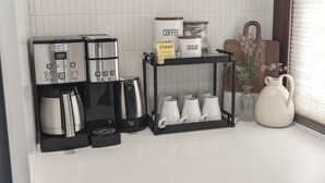 A kitchen area with a coffee maker, a coffee grinder, and a shelf with coffee and sugar containers. - 2 Bedroom Craftsman:KING Bed:Office:Views:Parking::Between Disney/Universal (Whittier)