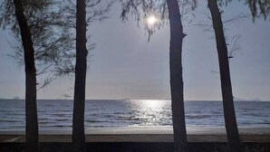A beach with tall trees and a calm sea. - The Chevalley beach resort  (Thung Wa)