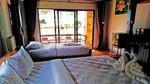 A hotel room with two beds, a balcony with chairs, and a swan decoration on the bed. - The Chevalley beach resort  (Thung Wa)