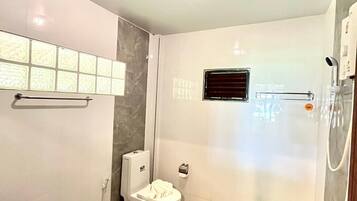 A modern bathroom with a toilet, bidet, and shower.