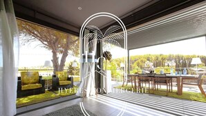 Ein modernes Interieur mit einem großen Fenster, einem Essbereich und einer Sitzecke mit gelben Sofas.
