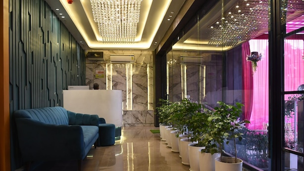A reception area with a modern design, featuring a reception desk, seating area, and potted plants. - Hotel Majestic Grand By MNG Rooms (Kanpur)