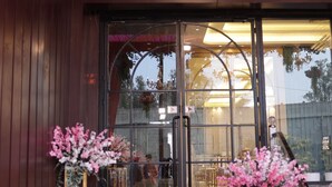 A building entrance with a wooden facade, a glass door, and steps leading up to it. - Hotel Majestic Grand By MNG Rooms (Kanpur)