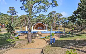 Enjoy live performances and events in this serene outdoor amphitheater surrounded by lush greenery and tall trees.