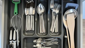 A drawer with various kitchen utensils including whisks, spoons, forks, and spatulas. - 35qm Serviced Apartment (Töging am Inn)