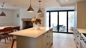 A modern kitchen with a central island, pendant lighting, and a view to the outdoors.