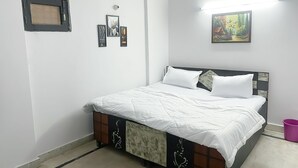 Une chambre à coucher avec un lit, une fenêtre et un tableau accroché au mur.