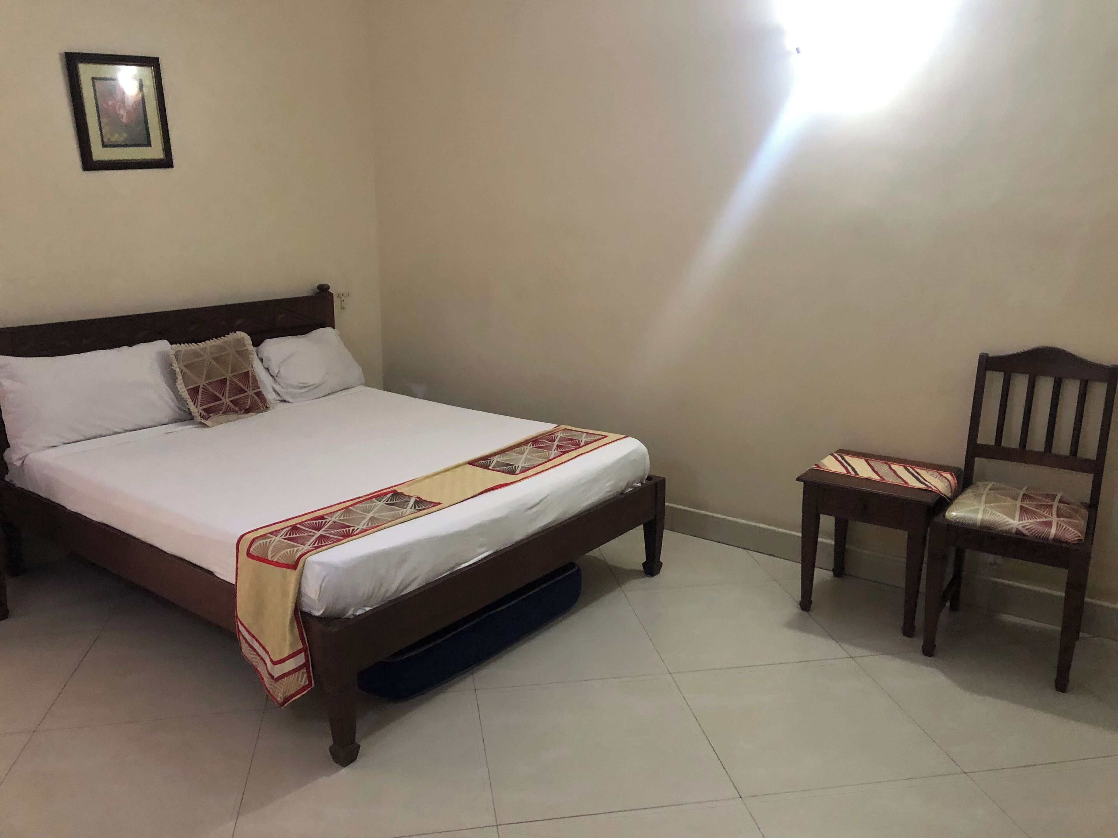 Ein Schlafzimmer mit einem Bett, einem Sessel und einem kleinen Tisch.