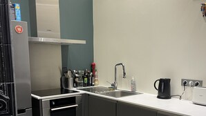 A modern kitchen with a built-in oven, a stainless steel sink, and a coffee maker.
