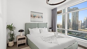 A modern bedroom with a large bed, a city view, and a minimalist decor. - World Class | 2BR | Dubai Skyline & Sea view (Downtown)