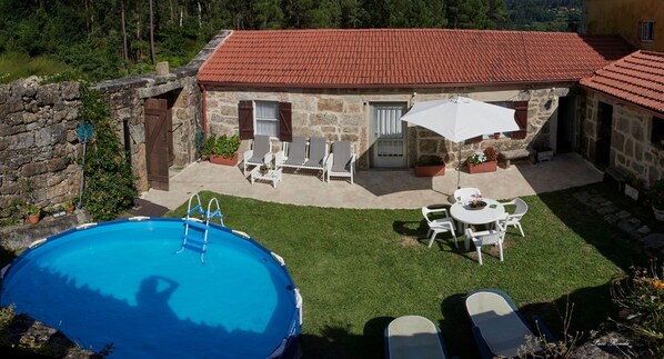 A stone house with a red-tiled roof, a swimming pool, and outdoor seating. - THE HOUSE OF MILA (Crecente)