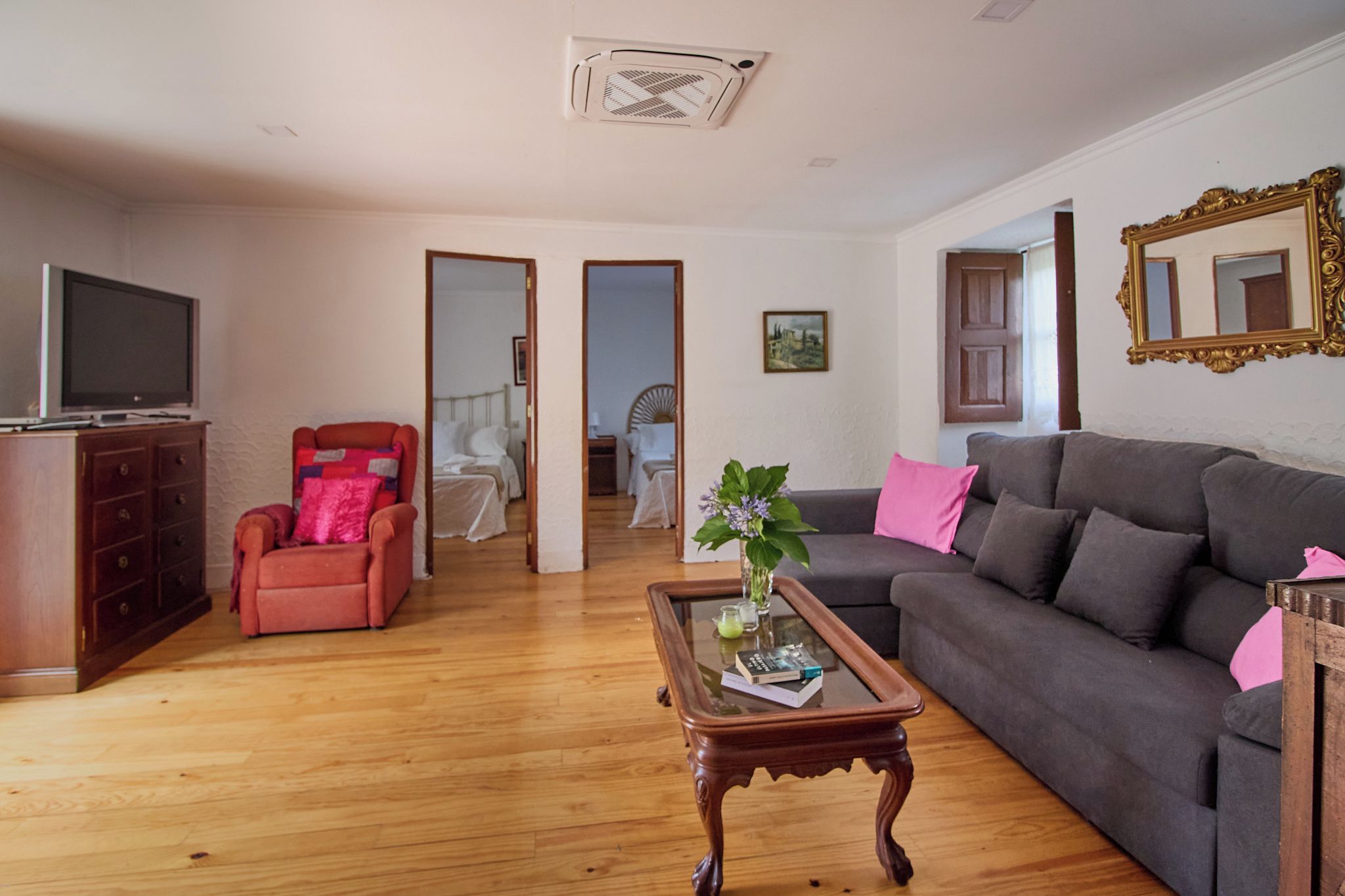 Een woonkamer met een bank, fauteuil, salontafel en een televisie.
