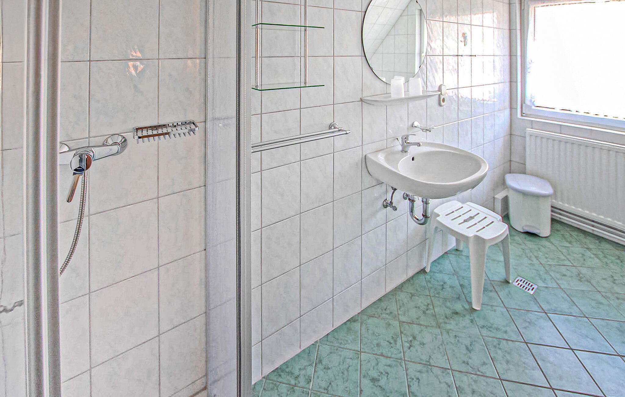 A bathroom with a shower, sink, and toilet.