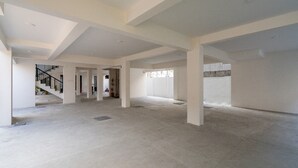 A spacious, unfinished interior with high ceilings and exposed concrete floors. - J Square Inn (Coimbatore)