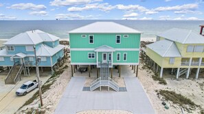 Una propiedad frente a la playa con casas de dos pisos, una escalera central y vista al océano.