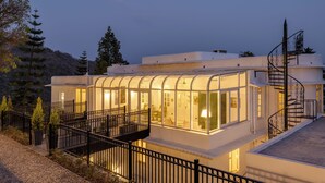 Un edificio moderno con fachada de vidrio, un balcón y una escalera de caracol.