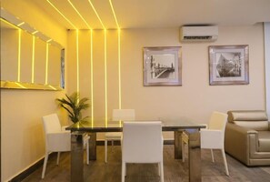 Enjoy a stylish space with a glass-top dining table, comfortable sofa, and framed artwork.