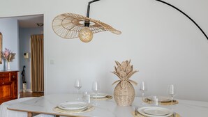 A dining area with a white marble table, wicker centerpiece, and white cushioned chairs. - A little sun in Paris with balconies, 15 minutes from Porte de Versailles (Paris)