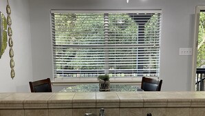 A kitchen with a built-in sink, two chairs, a window with blinds, and a welcome sign. - Lovely and Cozy 1 bedroom apartment  (Pearland)