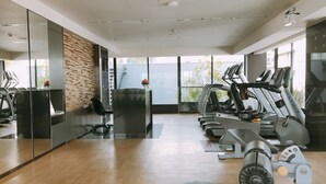 Een moderne sportschool met een receptiebalie, trainingsapparatuur en grote ramen.