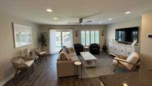 A spacious living room with a sofa, chairs, a coffee table, and a TV. - New to the Vacation Market! Unit 2B Canal Place (Lewes)