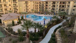 A hotel with a swimming pool surrounded by lounge chairs and palm trees. - Sunset Point: 3 bedroom, 3 baths, 3rd Floor Condo.  Pool and Hot Tub. (St. George)