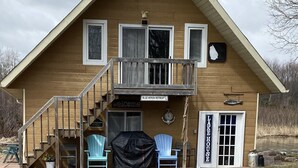 Une cabane en bois à deux étages, dotée d’un balcon, d’une pancarte d’accueil et d’un panneau indiquant « Blue Heron Retreat ».