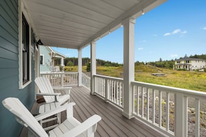 A covered porch with white railings and Adirondack chairs. - Seabrook Starry Meadow | Hot Tub, Gas Grill | 4BR, Sleeps 8, Fernwood (Pacific Beach)