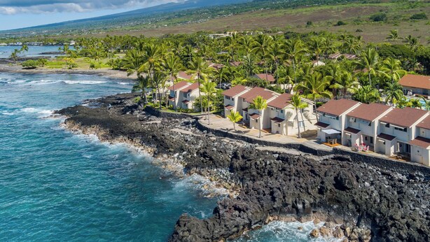 Un hôtel situé sur la côte, avec des chambres donnant sur l’océan, et caractérisé par un rivage rocheux et une végétation luxuriante.