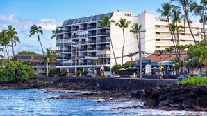 A hotel with multiple floors, balconies, and a view of the ocean. - Kona Alii 707 Stunning Top Floor Penthouse w/ Roof Top Deck, AC, & Elevators (KAILUA KONA)