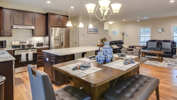 A modern kitchen with dark wood cabinets, stainless steel appliances, and a central island with seating. - Country Home Close to Pinehurst Golf Courses! (West End)