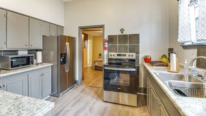 A modern kitchen with stainless steel appliances, a microwave, and a large oven. - Cozy Vicksburg Home w/ Patio ~ 1 Mi to Riverfront! (Vicksburg)