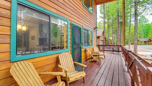 Eine Holzdiele mit Veranda, Holzstühlen und einem Tisch.
