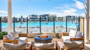 A rooftop lounge with a fire pit, overlooking a swimming pool and modern buildings. - Persian Bliss 10 Bedroom Townhouse (St. George)