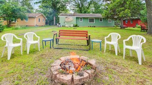 A fire pit with a bench and chairs in a grassy area with houses in the background. - Family-friendly Home w/ Fire Pit in Pine River (Pine River)
