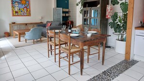 Un comedor con mesa y sillas de madera, un sofá azul y una estantería.