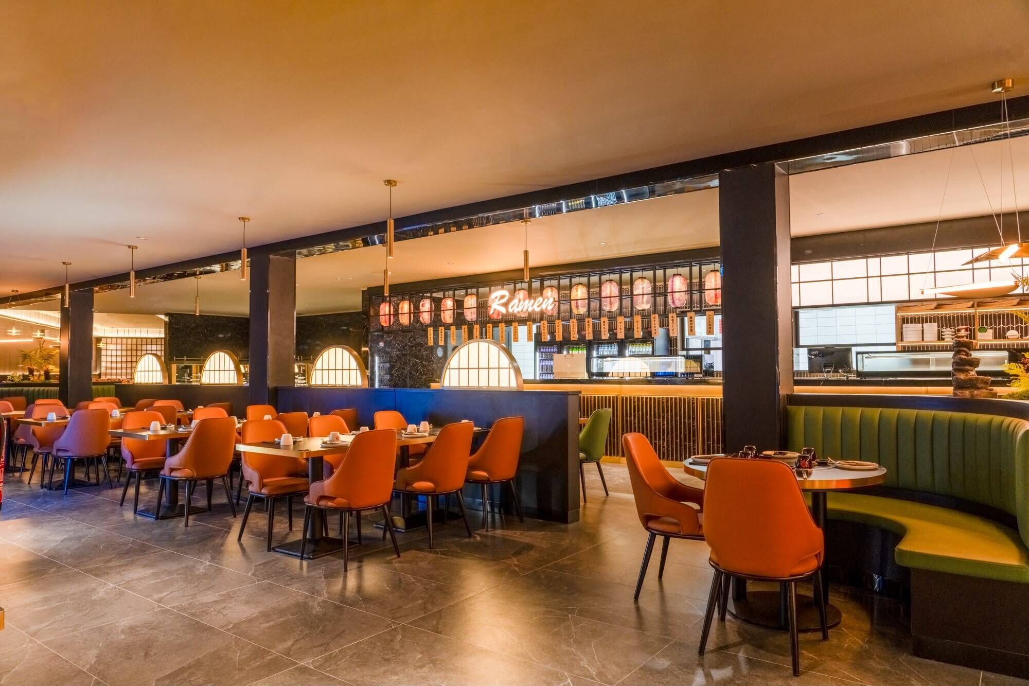 Un restaurante con mesas y sillas, una barra y una zona de bar.
