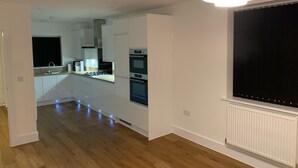 A modern kitchen with white cabinetry, a built-in oven, and a gas stove. - Brand New Entire 4 Bed House/multiple Parking (South Ockendon)