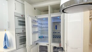 Une cuisine moderne équipée d’un réfrigérateur, d’un four et d’un four à micro-ondes intégrés.