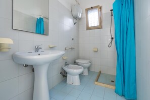 A bathroom with a sink, bidet, toilet, and a shower curtain. - 3790 Casa Nina by Barbarhouse (Porto Cesareo)