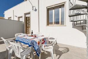 A patio with a table set for dining, white plastic chairs, and a window with a view. - 3790 Casa Nina by Barbarhouse (Porto Cesareo)