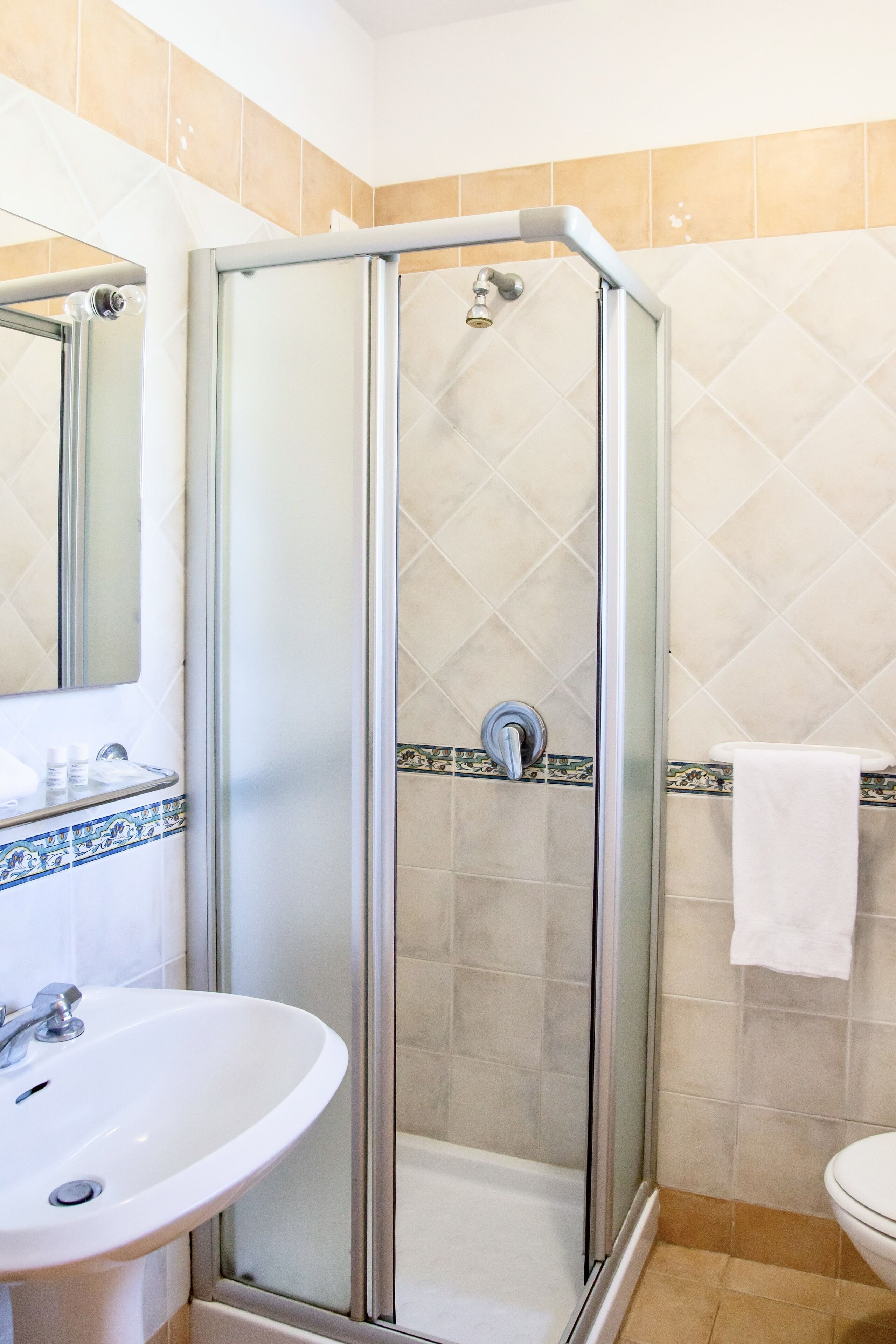 Une salle de bain avec une douche à parois de verre, un lavabo et des toilettes.
