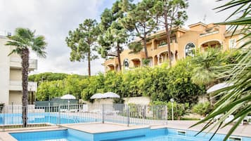 Een seizoensgebonden buitenzwembad, parasols voor strand/zwembad