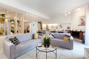 Un salon moderne avec deux canapés, une table basse et une bibliothèque.