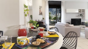 A modern living room with a dining area, featuring a sofa, a coffee table, and a TV. - Maison Wally in Sorrento (Sorrento)